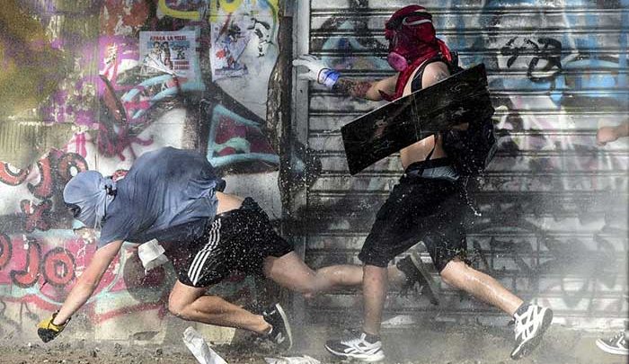 معترضان شیلی در حال فرار از تعقیب پلیس